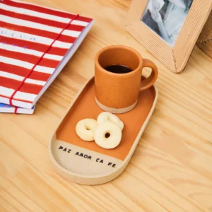 Bule de cerâmica com café e biscoitos em bandeja