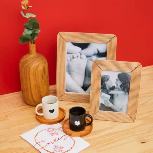 Decoração com porta-retratos e xícaras sobre mesa de madeira