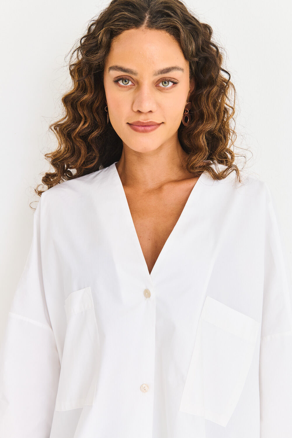 Modelo usando camisa branca com botões