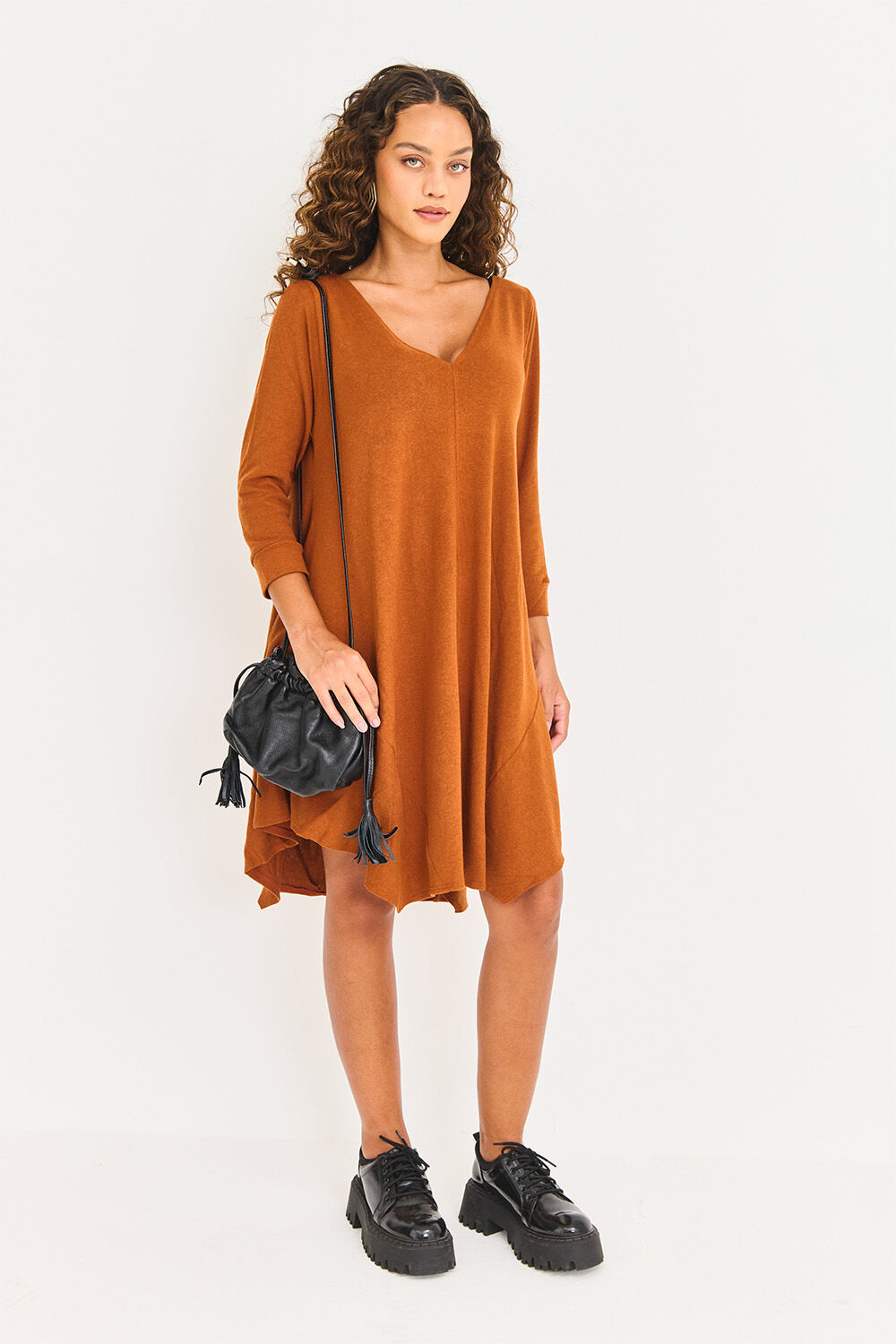 Modelo usando vestido laranja com bolsa preta